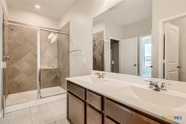 bathroom featuring tile patterned flooring, vanity, and an enclosed shower