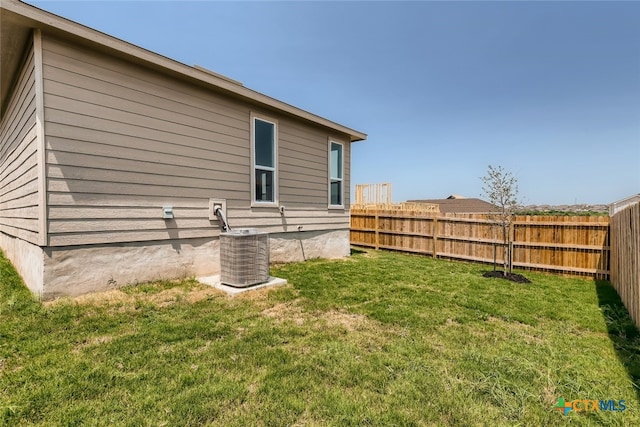 exterior space with central air condition unit and a yard