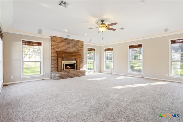 unfurnished living room featuring plenty of natural light, ceiling fan, crown molding, and light carpet