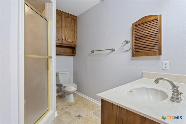 bathroom featuring vanity, an enclosed shower, and toilet