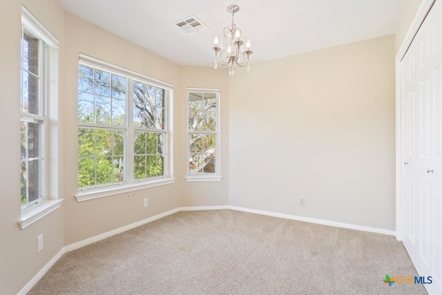 unfurnished room with carpet and a chandelier