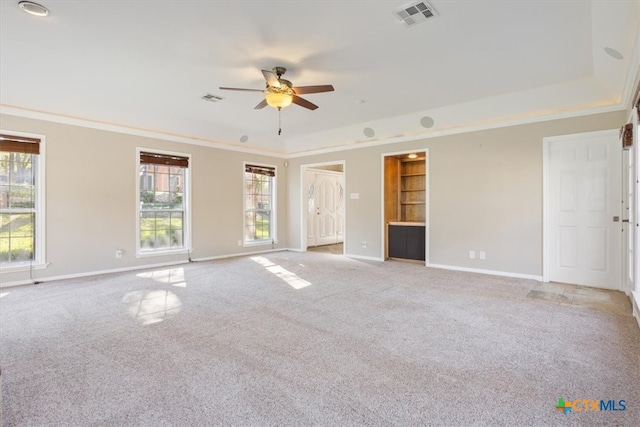 spare room featuring ceiling fan, crown molding, and light carpet