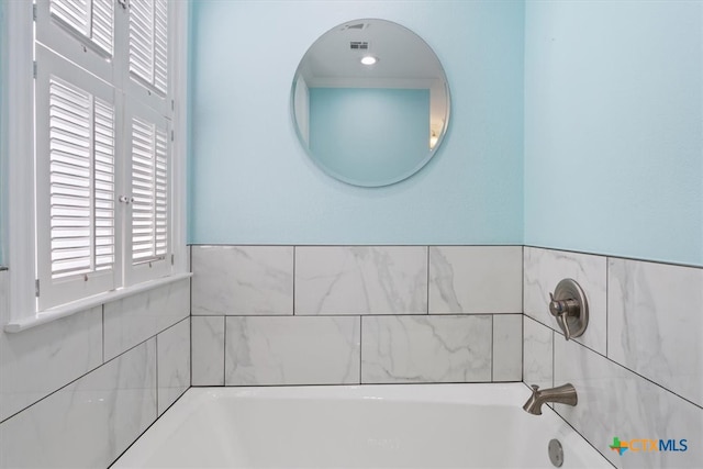 bathroom featuring a tub and a healthy amount of sunlight