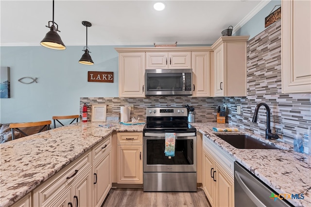 kitchen with ornamental molding, stainless steel appliances, hanging light fixtures, and sink