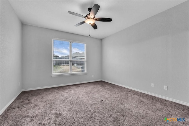 carpeted spare room with ceiling fan and baseboards