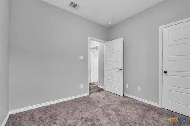 unfurnished bedroom with carpet, visible vents, and baseboards