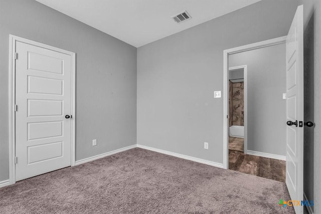 unfurnished bedroom with baseboards, visible vents, and dark colored carpet