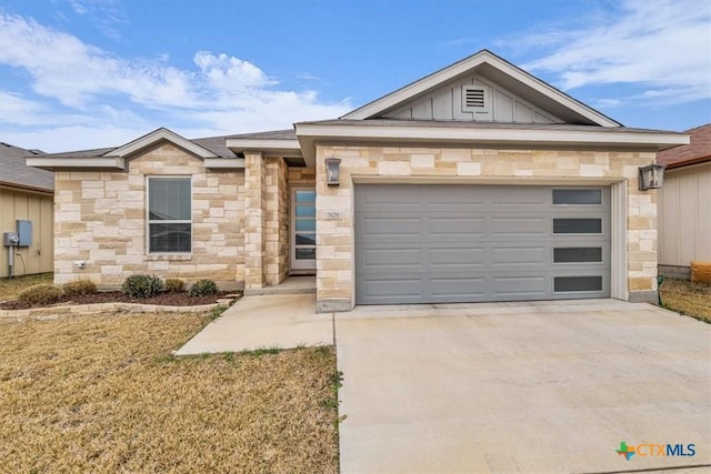 ranch-style home featuring concrete driveway, stone siding, board and batten siding, and an attached garage