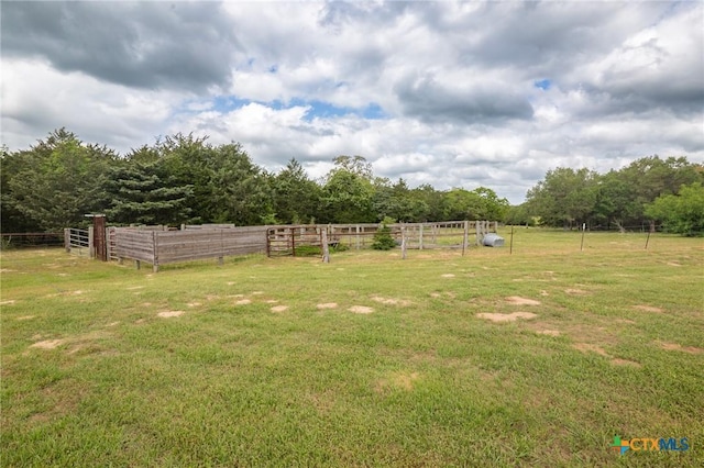 view of yard with fence and a rural view