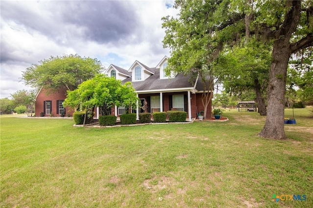 cape cod home with brick siding and a front lawn