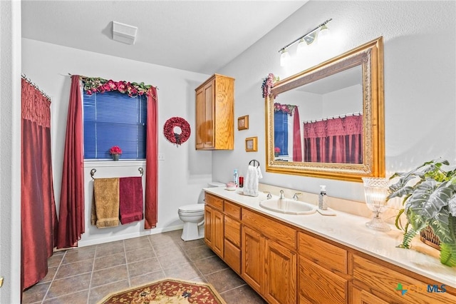 full bath featuring tile patterned flooring, vanity, and toilet