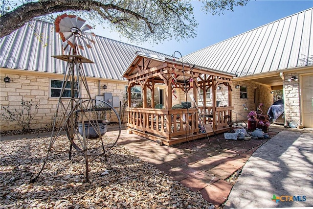 wooden terrace with a gazebo and area for grilling