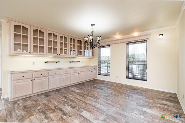 interior space featuring hanging light fixtures, wood finished floors, glass insert cabinets, and crown molding