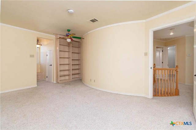 spare room with ornamental molding, light colored carpet, ceiling fan, and baseboards