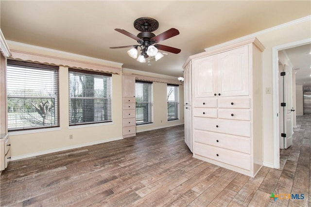 empty room featuring ornamental molding, wood finished floors, and baseboards