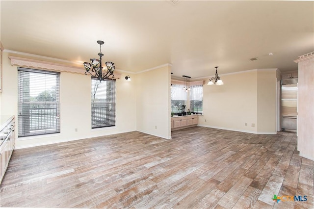 interior space with an inviting chandelier, light wood-style flooring, ornamental molding, and baseboards