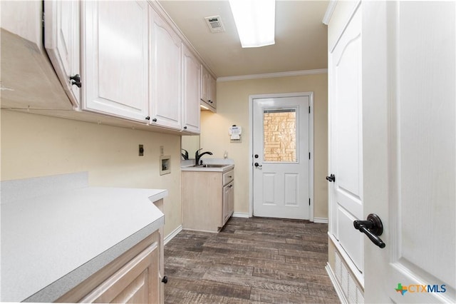 laundry area with cabinet space, ornamental molding, dark wood-style flooring, a sink, and electric dryer hookup