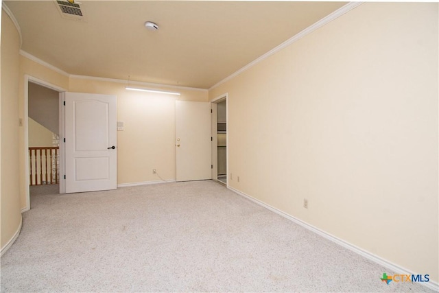 spare room featuring light carpet, baseboards, visible vents, and crown molding