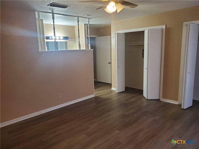 unfurnished bedroom featuring ceiling fan, a textured ceiling, and dark hardwood / wood-style floors