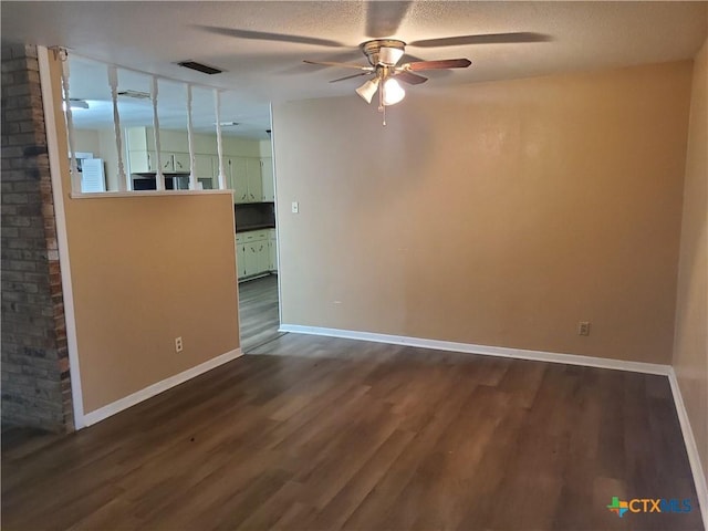 unfurnished room with ceiling fan, dark wood-type flooring, and a textured ceiling