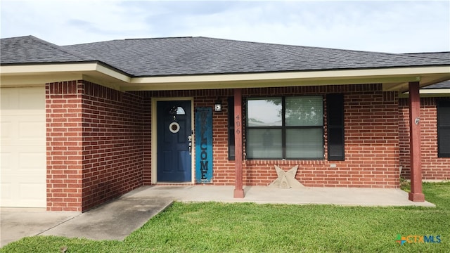 property entrance with a garage and a lawn