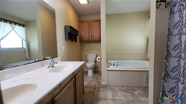 bathroom featuring a washtub, vanity, tile patterned floors, and toilet