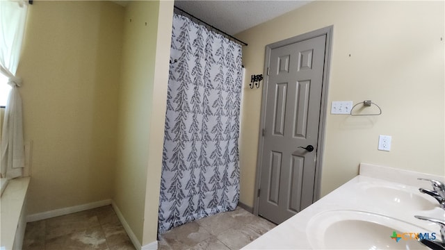 bathroom featuring walk in shower, vanity, and a textured ceiling