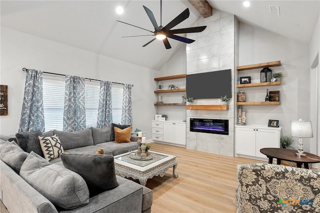 living room with light hardwood / wood-style floors, high vaulted ceiling, a fireplace, ceiling fan, and beamed ceiling