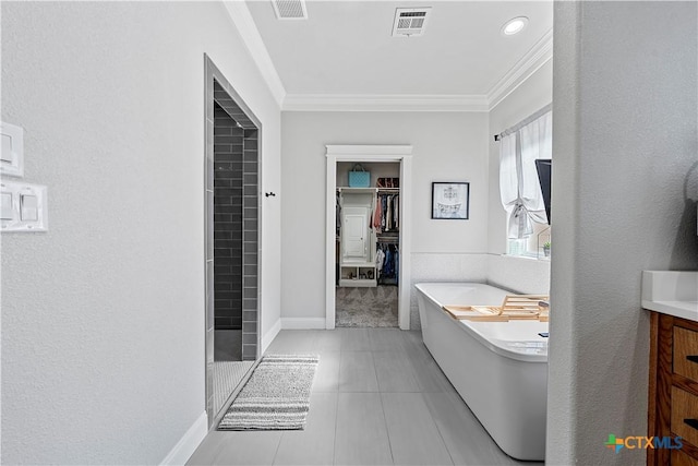 bathroom with ornamental molding, tile patterned floors, vanity, and a bathing tub