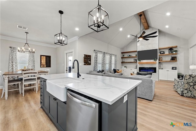 kitchen featuring a large fireplace, light stone countertops, dishwasher, hanging light fixtures, and a center island with sink