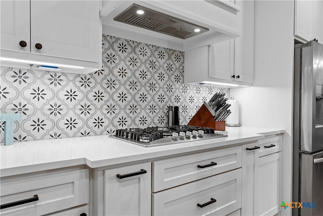 kitchen featuring stainless steel appliances, white cabinets, decorative backsplash, and custom range hood