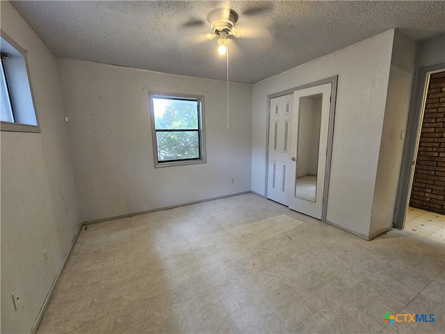 unfurnished bedroom with a textured ceiling, a closet, and ceiling fan