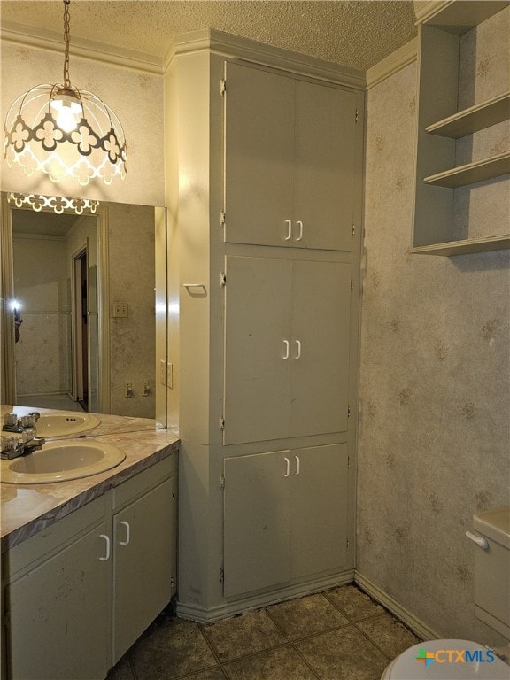 bathroom with tile patterned flooring, vanity, a textured ceiling, and toilet