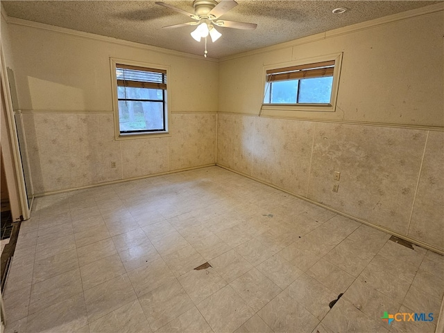 spare room with a textured ceiling, ceiling fan, and crown molding