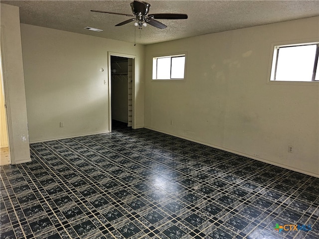 spare room featuring ceiling fan and a textured ceiling