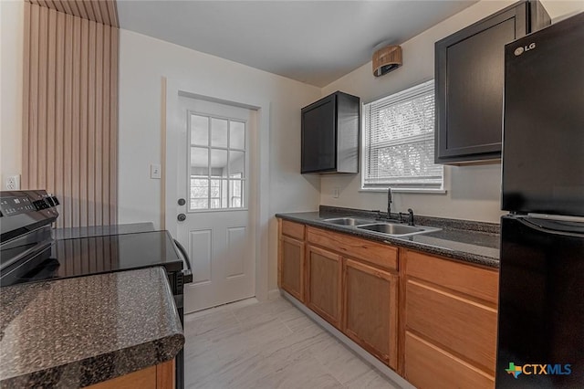 kitchen with black fridge, sink, dark stone countertops, and electric range oven