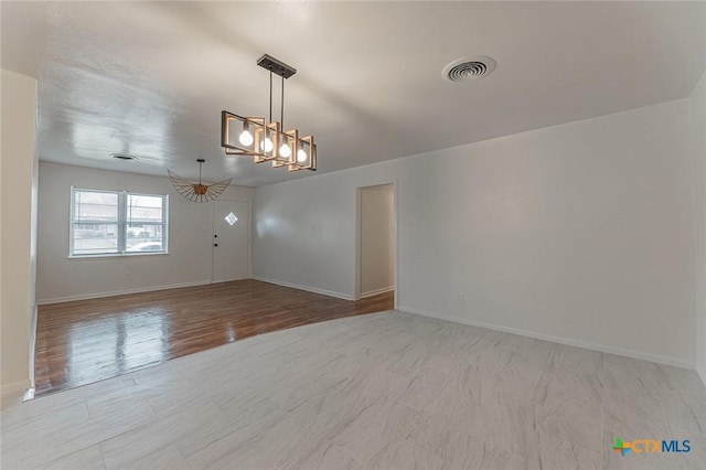 spare room featuring a notable chandelier