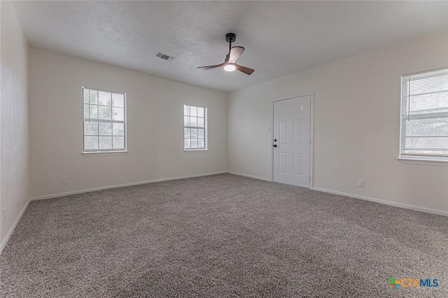 carpeted empty room with a textured ceiling and ceiling fan