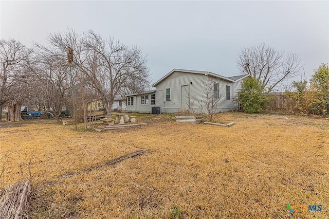 view of side of property featuring central air condition unit and a lawn