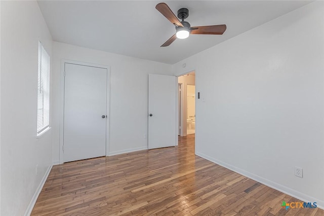 unfurnished bedroom featuring hardwood / wood-style flooring, ceiling fan, and a closet