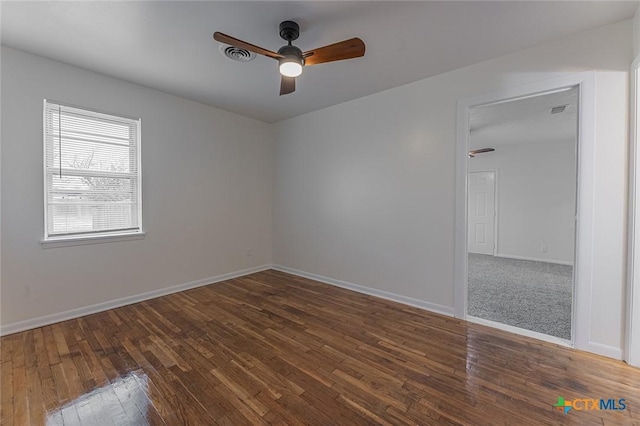 spare room featuring dark wood-type flooring and ceiling fan