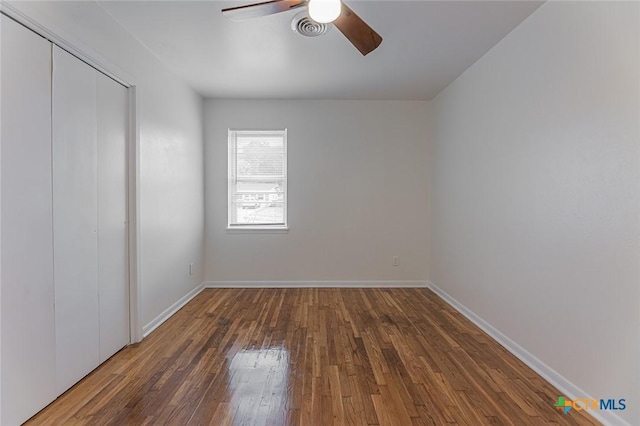 empty room featuring ceiling fan and dark hardwood / wood-style flooring