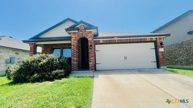 5711 Stonehaven Dr, Temple, TX 76502 - view of front of home featuring brick siding, a garage, a front yard, and concrete driveway