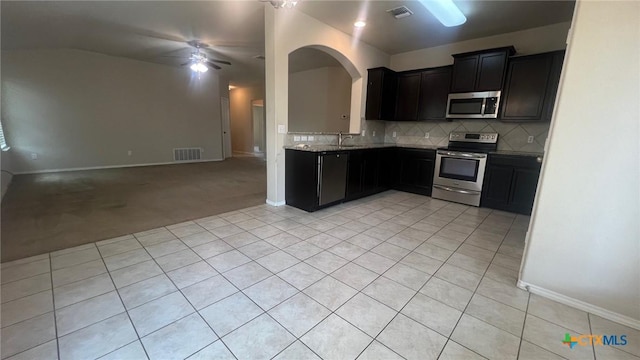 5711 Stonehaven Dr, Temple, TX 76502 - kitchen with appliances with stainless steel finishes, open floor plan, light tile patterned flooring, ceiling fan, and decorative backsplash