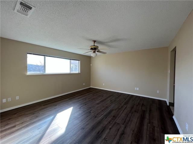 spare room featuring a textured ceiling, ceiling fan, and dark wood-type flooring