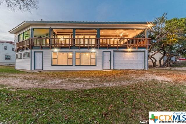 back of house featuring a balcony and a garage