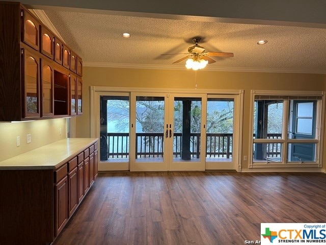 interior space with ceiling fan, french doors, dark hardwood / wood-style flooring, a textured ceiling, and ornamental molding