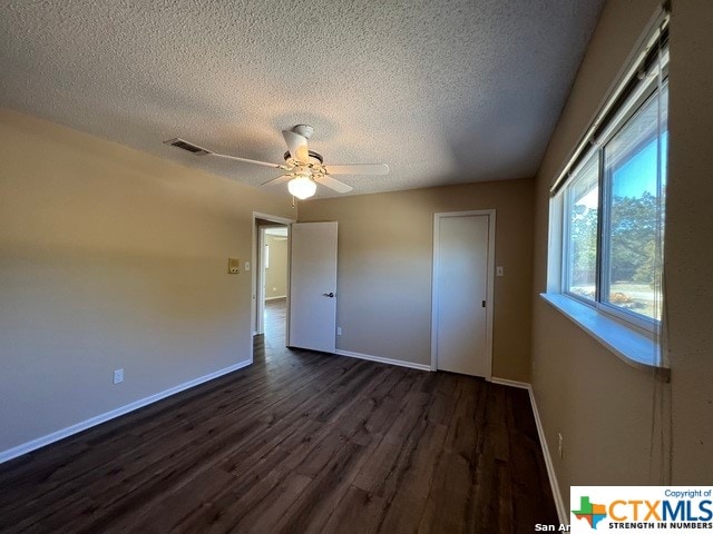 unfurnished bedroom with a textured ceiling, ceiling fan, and dark wood-type flooring