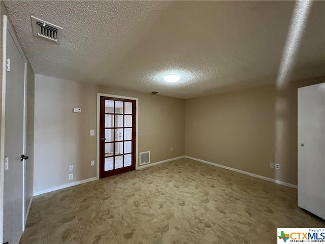 unfurnished room with a textured ceiling