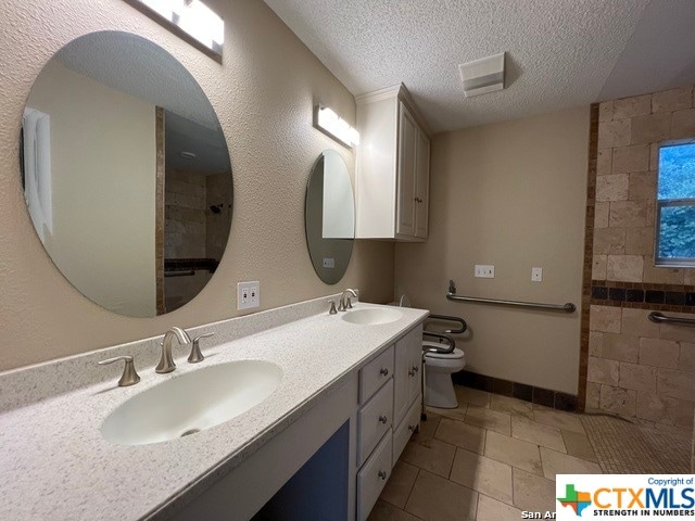 bathroom featuring tile patterned floors, vanity, a textured ceiling, a shower, and toilet